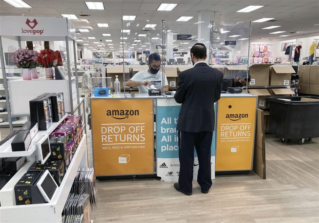 Customer returning a package return drop-off counter, illustrating an in-store product return and refund policy process.