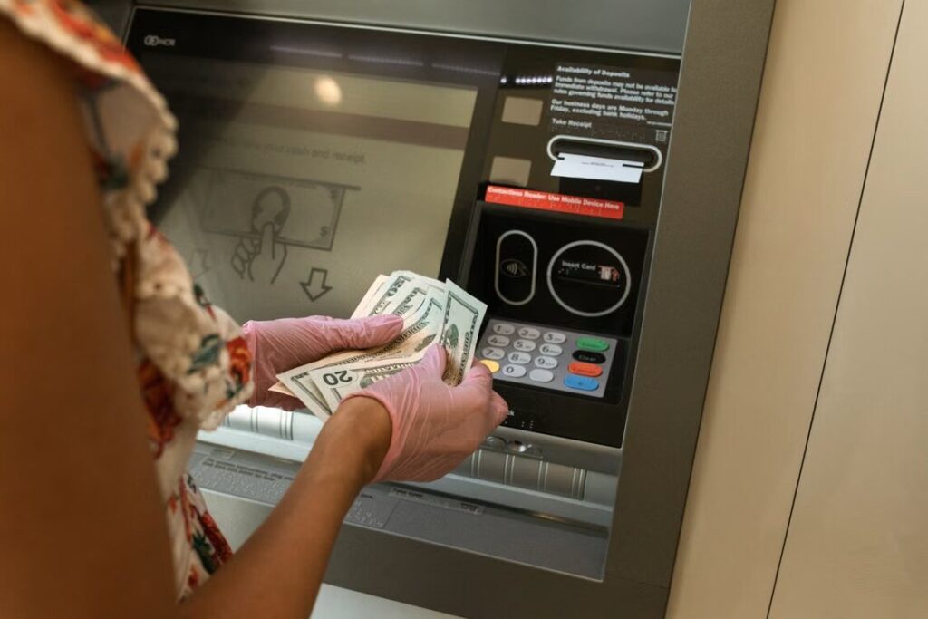 Traveler using an overseas ATM and checking currency conversion options before withdrawing cash.
